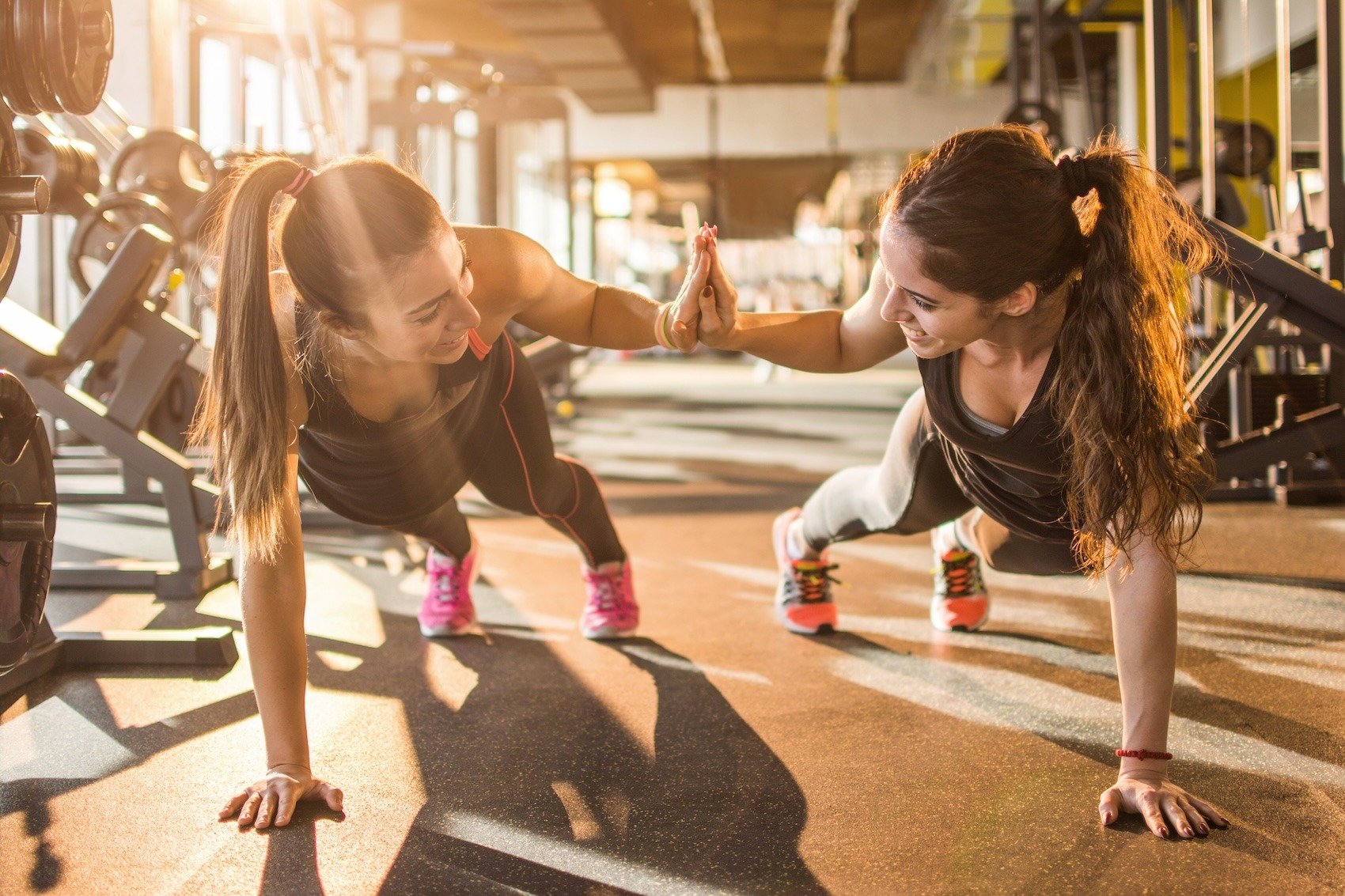 Two women working out together in a gym.